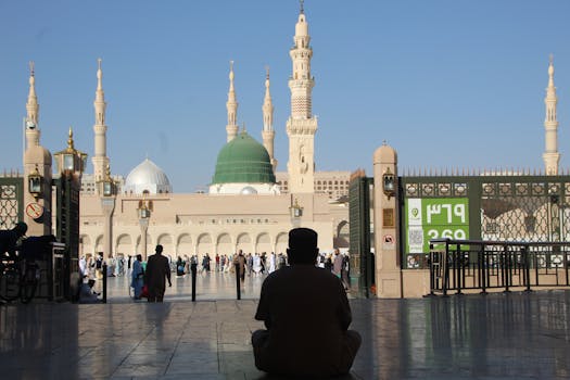 Silhouette of a person sitting in front of Al-Masjid an-Nabawi in Madinah, Saudi Arabia.